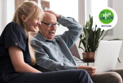 grand-père et petite fille regardant en riant ensemble une vidéo sur une tablette numérique