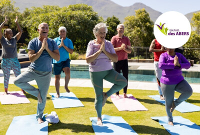 groupe de seniors faisant du yoga à l'extérieur en riant