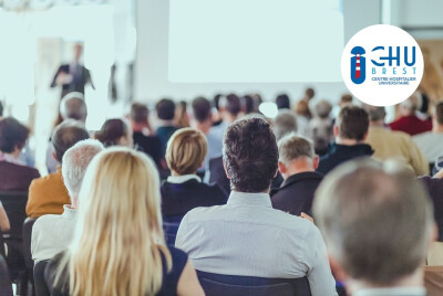 personnes de dos assistant à une conférence