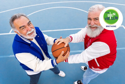 deux seniors homme se disputant en rigolant un ballon de basket