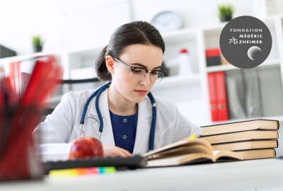 jeune femme médecin lisant des livres à son bureau