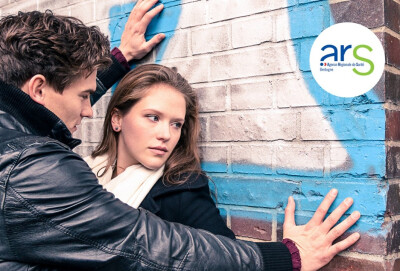 jeune homme bloquant une jeune femme contre un mur