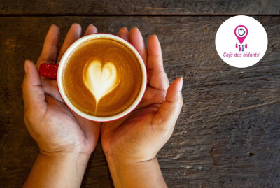 Gros plan main femme tenant une tasse de café mousse en forme de coeur