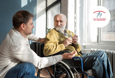 senior en situation de handicap aidé par un jeune homme pour prendre ses médicaments