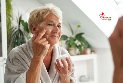 gros plan femme senior se mettant de la crème hydratante sur le visage