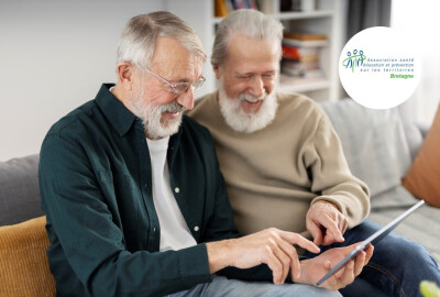 deux hommes seniors consultant une tablette en riant