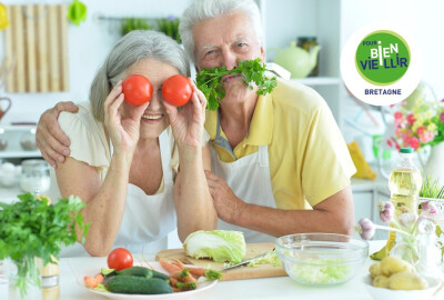 couple de seniors mettant tomates devant leur yeux