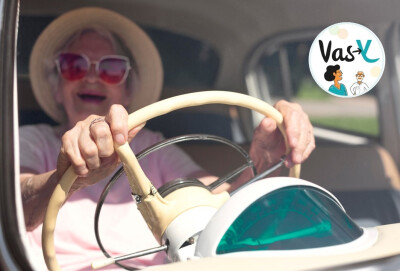 gros plan femme âgée conduisant sa voiture, habillée en rose et lunettes roses