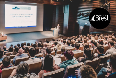 personnes suivant une conférence dans un amphi