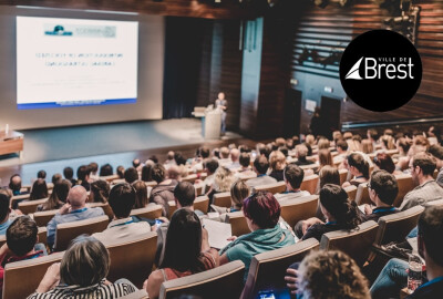 personnes de dos assistant à une conférence dans un amphi