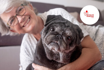 gos plan femme senior souriante tenant un chien dans ses bras