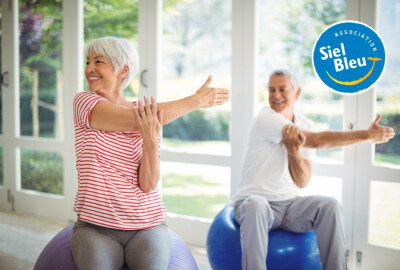 couple de seniors effectuant des exercices d'étirement sur un swissball