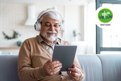 homme senior regardant une tablette numérique en souriant avec écouteurs sur les oreilles