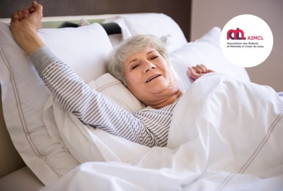 femme senior s'étirant dans son lit à son réveil