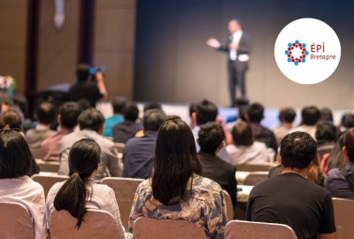 personnes de dos assistant à une conférence