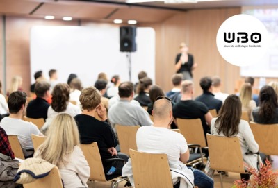 personnes de dos assistant à une conférence