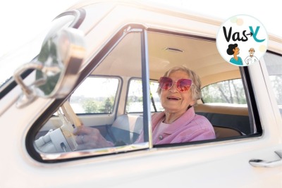 femme senior portant des lunettes roses en conduisant sa voiture