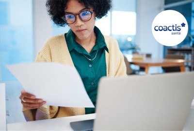 jeune femme consultant des notes devant son ordinateur portable