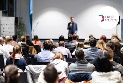 personnes de dos assistant à une conférence