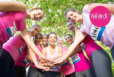 groupe de femmes en tenue de sport rose joignant collectivement leurs mains en guise de soutien
