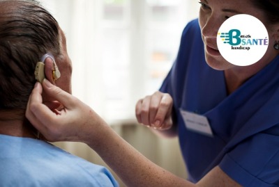 soignante vérifiant l'appareil auditif d'un patient
