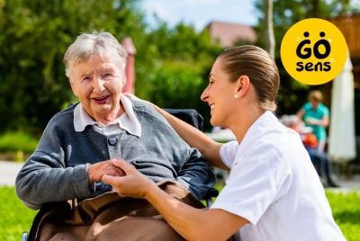 vue d'une soignante et d'une femme âgée en situation de handicap, en extérieur