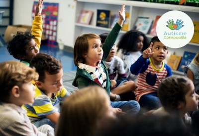groupe d'enfants dans une salle de classe levant la main pour répondre à une question