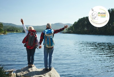 seniors en excursion, de dos, sur des rochers face à un lac