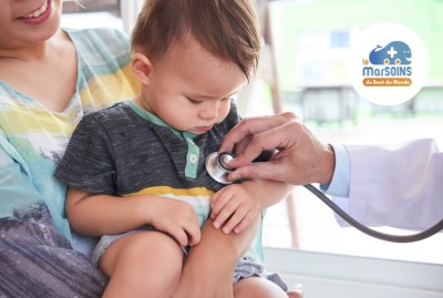 petit garçon regardant avec curiosité le stéthoscope du médecin posé sur sa poitrine pendant un examen