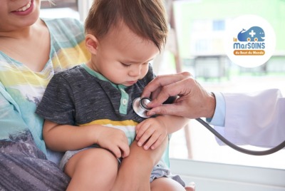 petit garçon regardant avec curiosité le stéthoscope du médecin posé sur sa poitrine pendant un examen