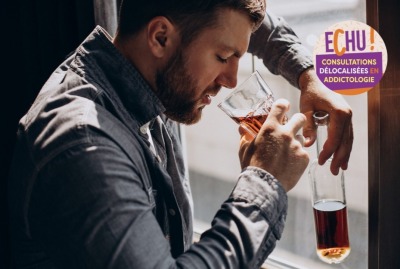 homme buvant de l'alcool appuyé à une fenêtre