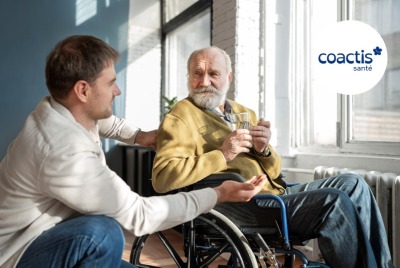 jeune homme se tenant auprès d'un homme senior en fauteuil