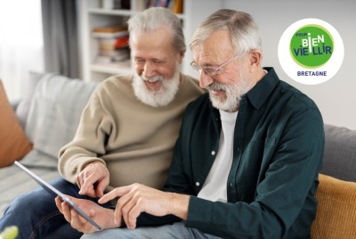 deux hommes seniors utilisant une tablette en riant