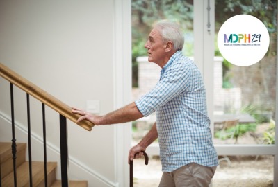 homme senior avec une canne hésitant à monter les escaliers d'une maison