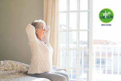 femme senior s'étirant à son réveil sur son lit