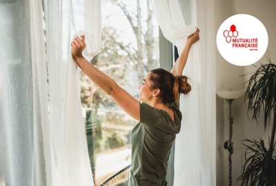 jeune femme ouvrant ses fenêtres en grand et respirant l'air frais