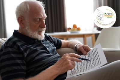 gros plan homme senior faisant un exercice de logique assis dans son canapé