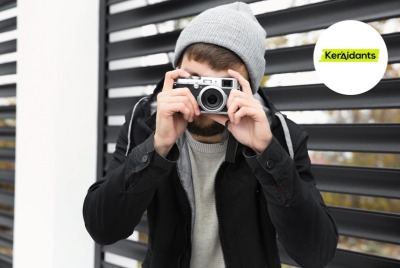 jeune homme regardant vers l'objectif derrière un appareil photo