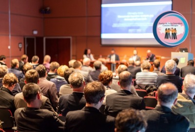 personnes de dos assistant à une conférence