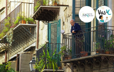 vieil homme accoudé à balcon regardant rue