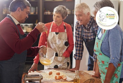 groupe de seniors pendant un cours de cuisine avec une animatrice