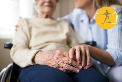 gros plan mains mêlées d'une femme et d'une senior en fauteuil roulant