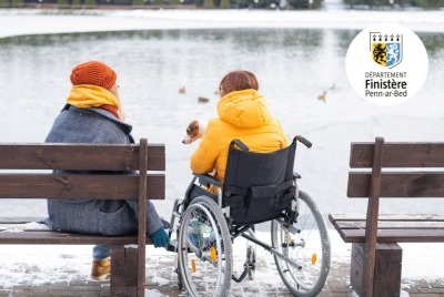 deux femmes de dos, dont l'une en situation de handicap, contemplant un lac gelé