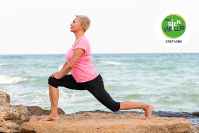 gros plan femme senior faisant une pose de yoga face à la mer