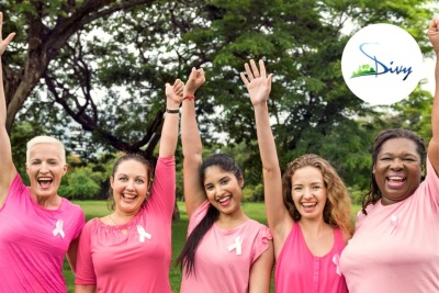 groupe de femmes habillées en rose et portant un ruban rose sur la poitrine levant les poings