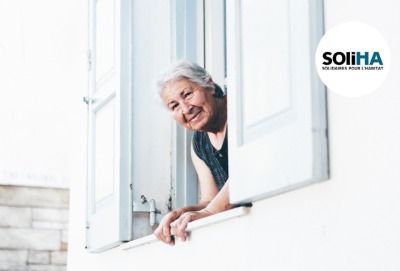 gros pan femme senior se penchant pour regarder par sa fenêtre