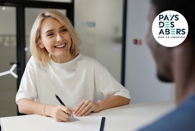 gros plan jeune femme souriante pendant qu'elle discute avec un candidat au recrutement, de dos
