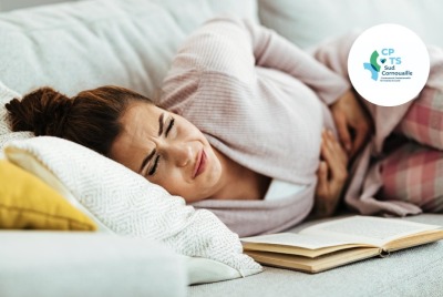 jeune femme allongée et se tenant le ventre douleurs abdominales