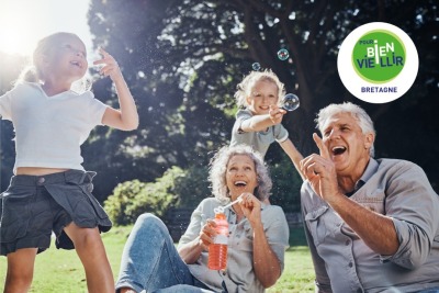 couple de seniors et leurs petits enfants jouant à l'extérieur avec des bulles de savon
