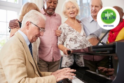 homme senior jouant du piano tandis que d'autres seniors chantent autour de lui